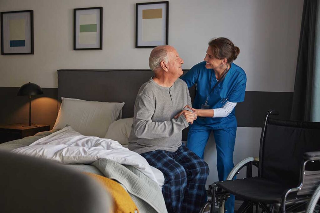 Two adults sitting with an elderly woman in a cozy living room, talking and looking at documents together.